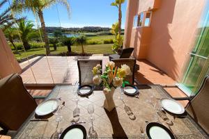 - une table à manger avec un vase de fleurs sur la terrasse dans l'établissement Luxury South Facing Ground Floor Apt at Mar Menor, à Torre-Pacheco