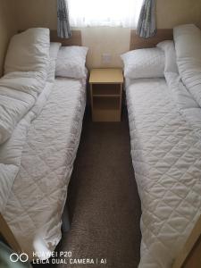 two beds sitting next to each other in a room at Lovely 2-Bed caravan in Walton on the Naze in Walton-on-the-Naze