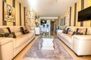 un salon avec deux canapés et une télévision dans l'établissement Luxury South Facing Ground Floor Apt at Mar Menor, à Torre-Pacheco