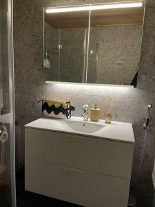 Ihana huoneisto Turun Kakolassa في توركو: حمام مع حوض أبيض ومرآة