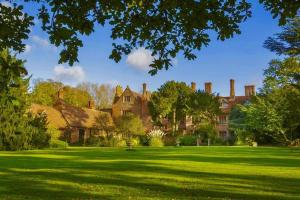 a large house with a green lawn in front of it at Breathtaking Elizabethan Manor House in Burnham-on-Crouch