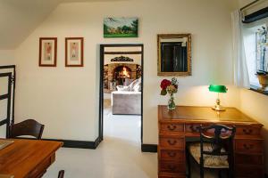 a room with a desk and a mirror and a bedroom at Breathtaking Elizabethan Manor House in Burnham on Crouch