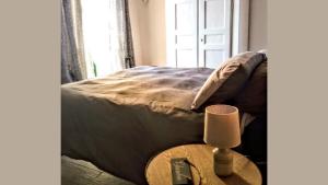 een slaapkamer met een bed en een tafel met een lamp bij Mysa Properties - Casa vacanze Arnasco in Arnasco