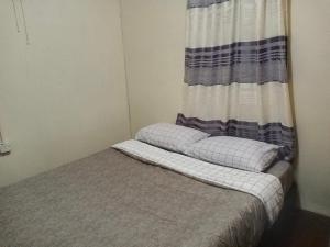 ein kleines Schlafzimmer mit einem Bett und einem Vorhang in der Unterkunft Juara Cottage in Tioman Island