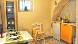 a kitchen with a counter and a table and chairs at Mysa Properties - Casa vacanze Arnasco in Arnasco
