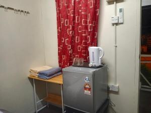 Cette chambre comprend un réfrigérateur et un rideau rouge. dans l'établissement Juara Cottage, à l'Île Tioman