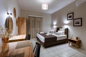 a hotel room with a bed and a dining room at Koulouris Apartments & Studios in Kalyves