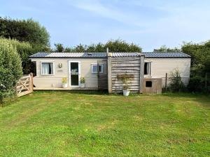 a small house in a yard with a grass yard at Cosy Quiet Static Caravan Mawgan Porth St Eval in Wadebridge