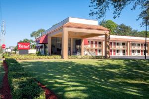 a building with a large lawn in front of it at Red Roof Inn Ft Pierce in Fort Pierce