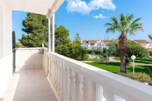 a balcony with a view of a palm tree at Bungalow Blue Dream 4 - Sea views, terrace and pool in Gran Alacant
