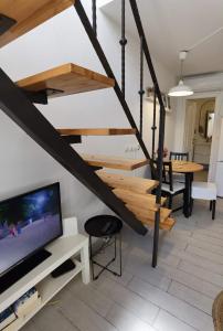 a living room with a staircase and a tv at Casa natura - Olib, gem of islands in Olib
