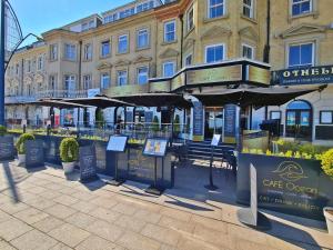 a cafe with tables and umbrellas in front of a building at Hotel Ocean in Great Yarmouth