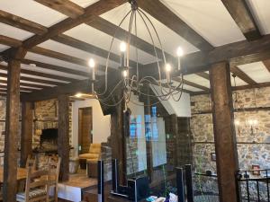 a chandelier hanging from a ceiling in a room at Къща Александрова с басейн вътрешен и отопляем in Arda