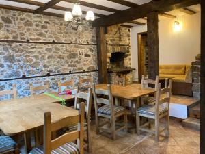 a dining room with wooden tables and chairs at Къща Александрова с басейн вътрешен и отопляем in Arda