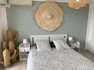 a bedroom with a bed and a basket on the wall at VUE SUR LES ILES D'OR in Hyères