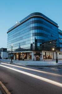 a large glass building on a city street at night at AZZ Asturias Langrehotel & Spa in Langreo