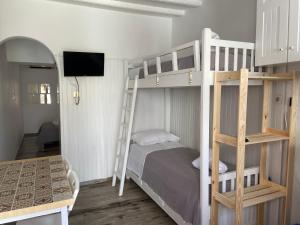 a bedroom with two bunk beds and a television at Elenitas Town house with Balcony and Sea View in Mýkonos City