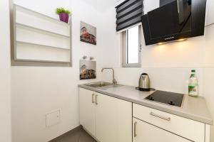 eine Küche mit einer Spüle und einer Mikrowelle in der Unterkunft Turmhotel Rhein-Main in Dreieich
