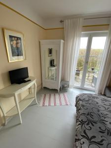 Schlafzimmer mit einem Bett und einem Schreibtisch mit einem Computer in der Unterkunft Villa Musica in Aschau im Chiemgau