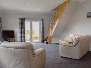 uma sala de estar com dois sofás e uma televisão em St Catherines em Porchfield