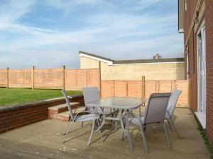 einen Tisch und Stühle auf einer Terrasse mit einem Zaun in der Unterkunft St Catherines in Porchfield