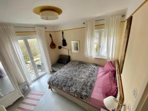ein Schlafzimmer mit einem Bett in einem Zimmer mit Fenstern in der Unterkunft Villa Musica in Aschau im Chiemgau