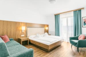 ein Hotelzimmer mit einem Bett und zwei Stühlen in der Unterkunft Hotel Weingut Rosenhof in Illmitz