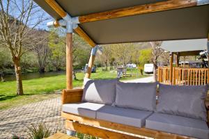 - une terrasse couverte avec un canapé dans un parc dans l'établissement Fellow Du Nord, à Goebelsmuhle