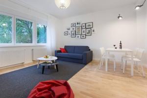 ein Wohnzimmer mit einem blauen Sofa und einem Tisch in der Unterkunft 4gZg Apartment in Zagreb