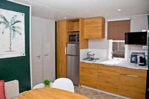 eine kleine Küche mit einem Tisch und einem Kühlschrank in der Unterkunft Chalet Fuusslee in Goebelsmuhle
