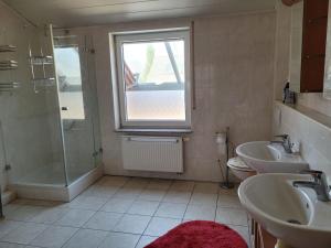 a bathroom with two sinks and a shower at Ferienhaus Vongerichten in Oberhausen