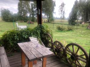 una mesa de madera en una terraza con un campo en Vedru Puhketalu, en Väike-Rakke