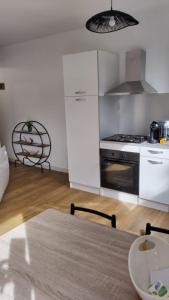 een keuken met een tafel en een fornuis top oven bij Les loges in Parthenay