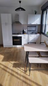 a kitchen with white cabinets and a wooden floor at Les loges in Parthenay