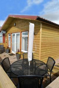 einen Tisch und Stühle auf dem Deck einer Hütte in der Unterkunft Pet friendly sleeps 6 Chalet Bridlington free elec in Bridlington