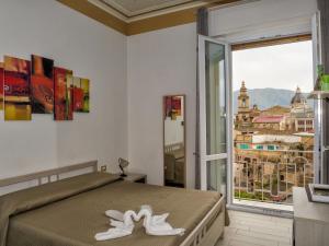 sypialnia z łóżkiem i dużym oknem w obiekcie Le Cupole Decò w mieście Palermo