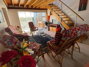 a living room with rocking chairs and a staircase at Jamaican Palms 27, Marina Martinique in Jeffreys Bay