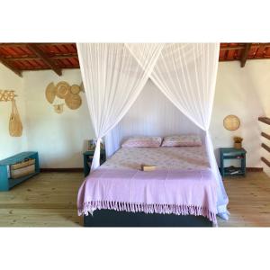 Casa Pitaya في كورومباو: غرفة نوم بسرير مع مظلة