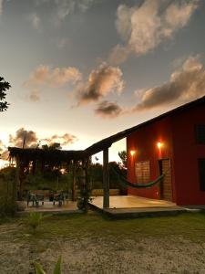 un edificio rojo con patio y mesa de picnic en Casa Pitaya en Corumbau