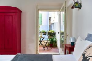 a bedroom with a red door leading to a patio at Al Cavour 34 in Trento