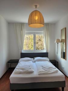 uma cama num quarto com uma grande janela em Falcon Lodge Kaprun Kitzsteinhorn - Steinbock Lodges em Kaprun