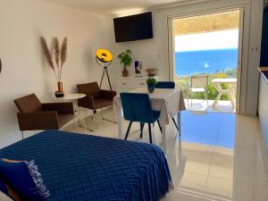 a bedroom with a bed and a table and a dining room at Villa Grand Baie in Agay - Saint Raphael