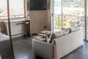 ein Wohnzimmer mit einem Sofa und einem großen Fenster in der Unterkunft Meteora Heaven and Earth premium suites - Adults Friendly in Kalambaka