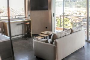 a living room with a couch and a large window at Meteora Heaven and Earth premium suites - Adults Friendly in Kalabaka