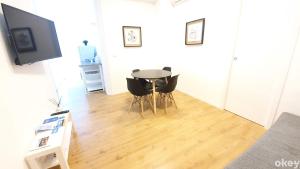salon ze stołem, krzesłami i telewizorem w obiekcie Bed & Relax Loft - Bari Centro w mieście Bari