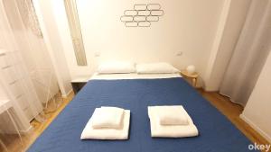 sypialnia z niebieskim łóżkiem i ręcznikami w obiekcie Bed & Relax Loft - Bari Centro w mieście Bari