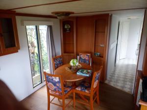 a dining room with a wooden table and chairs at De Boerenskuur..chalet.. in Assendelft