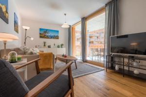 - un salon avec un canapé et une télévision dans l'établissement Montela Apartments by fewo-plan SAAS215, à Saas-Grund