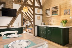 a kitchen with green cabinets and a wooden ceiling at Winnica Veneda in Ustka