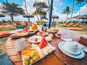 a wooden table with a tray of food on the beach at Maion Hotel e Boutique in Praia do Espelho